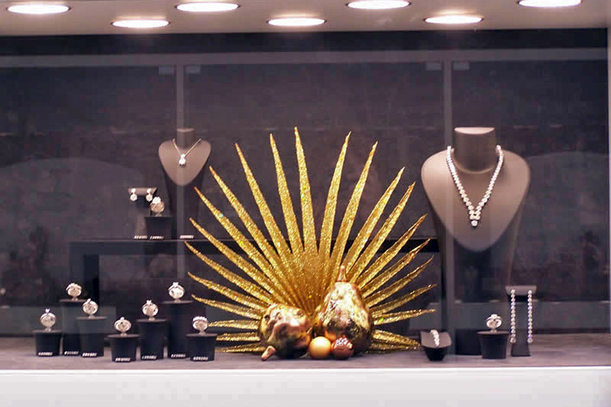 Naaranžované šperky ve vitríně doplněné o vytvořenou zlatou dekoraci