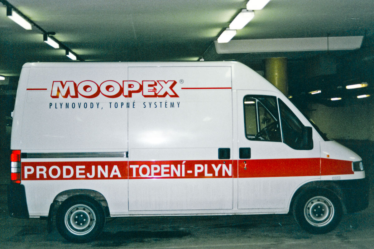 Moopex Peugeot Boxer v bílé barvě, nalepené logo a pruhy v červené, text černý